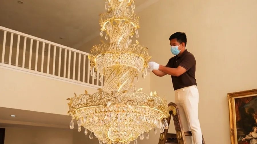 A crystal chandelier being cleaned piece by piece by MELLS in Dubai