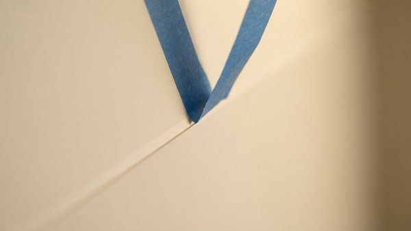 Masking tape applied along a clean wall to ceiling line before painting in Dubai