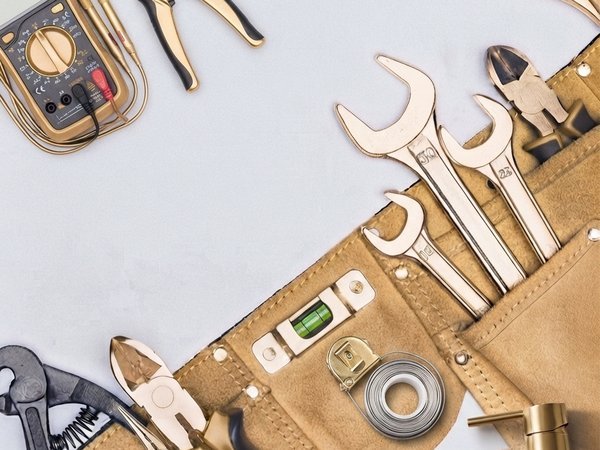MELLS technician tool roll with plumbing and electrical instruments laid out before a Dubai job